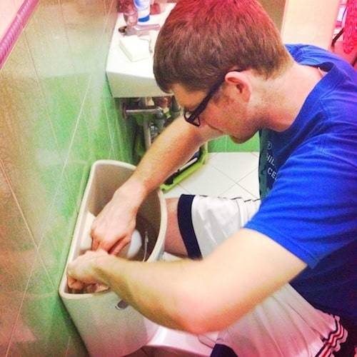 Man fixing a toilet.