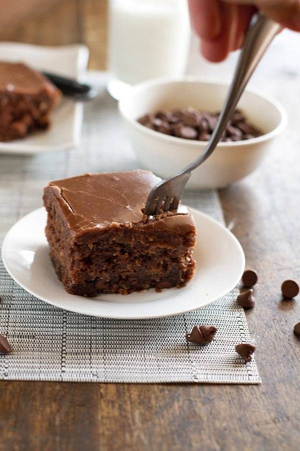 One piece of chocolate oatmeal cake on a white plate with a fork.