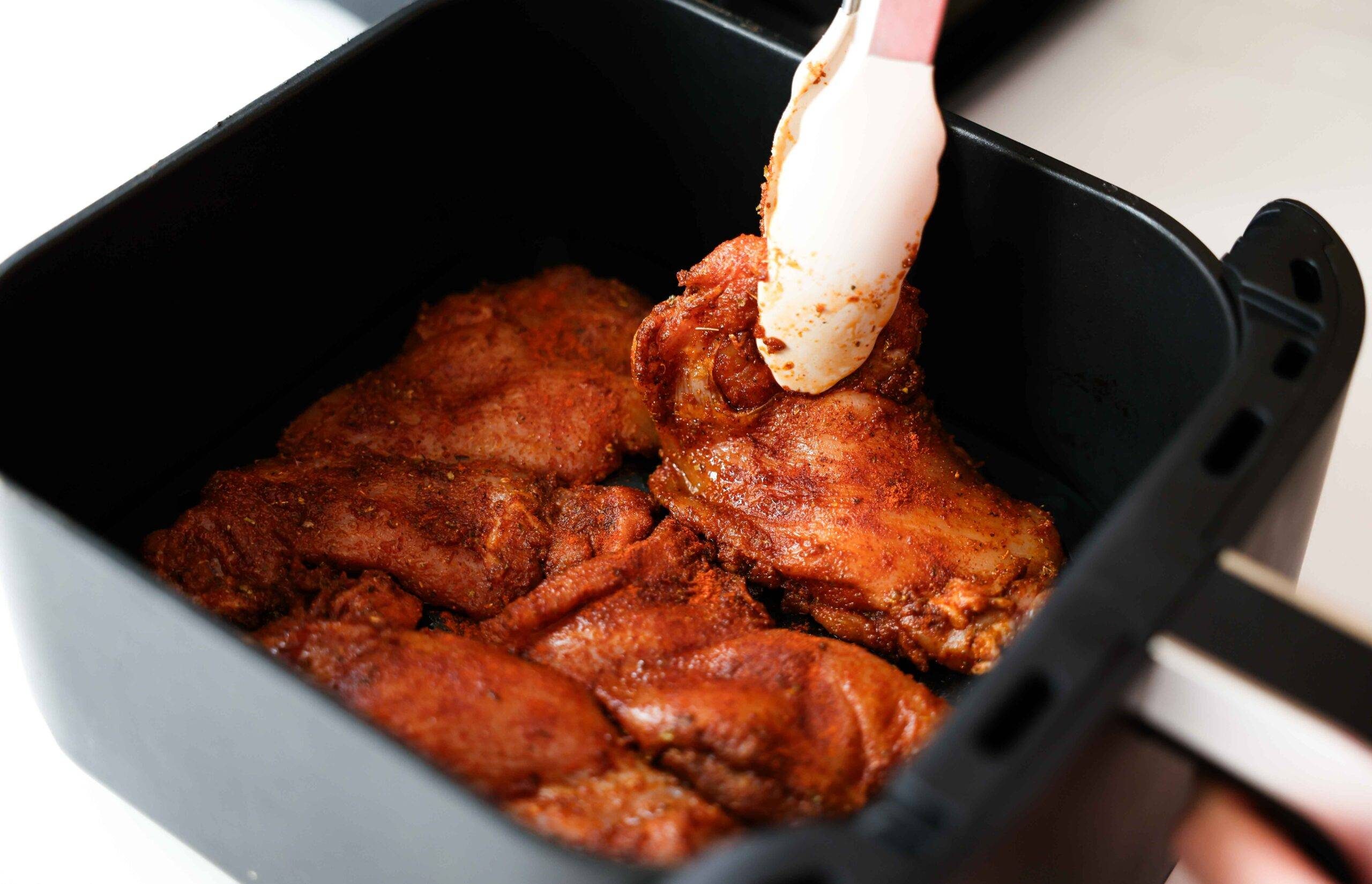 Putting the chicken thighs in the air fryer