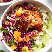 Chipotle salmon in a bowl with rice, slaw, and sauce.