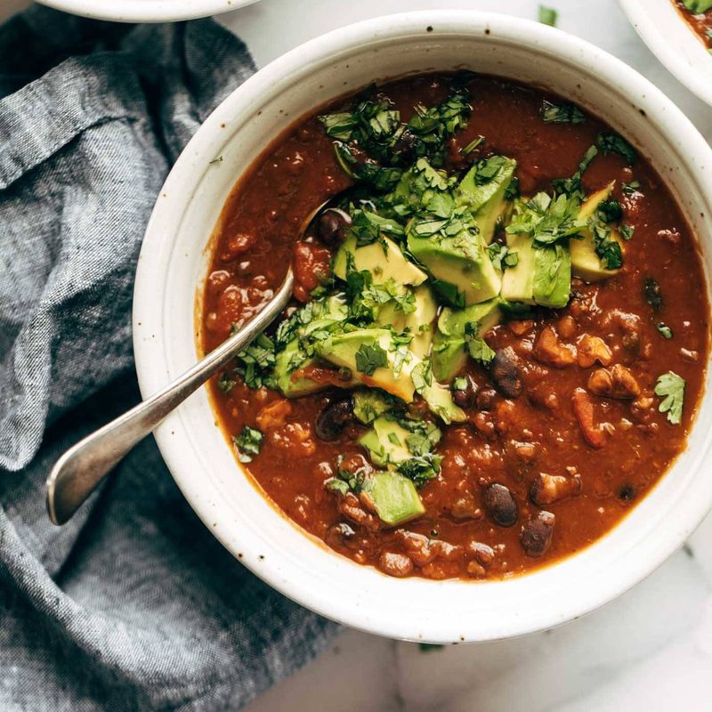 Chili in a bowl with a spoon and toppings.