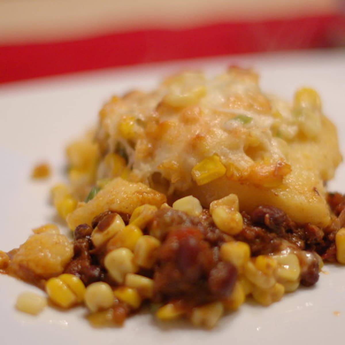 Chili-corn casserole with polenta on a white surface.