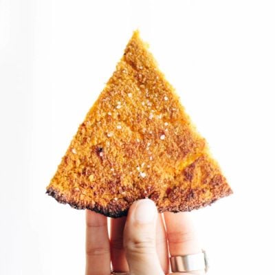 Sweet Potato Pizza Crust slice held by hand.